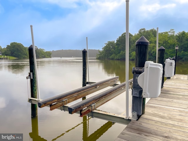 dock area with a water view and boat lift
