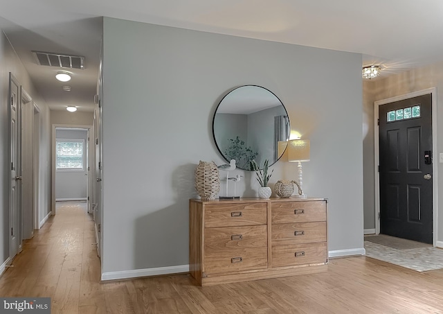foyer entrance featuring baseboards and light wood finished floors