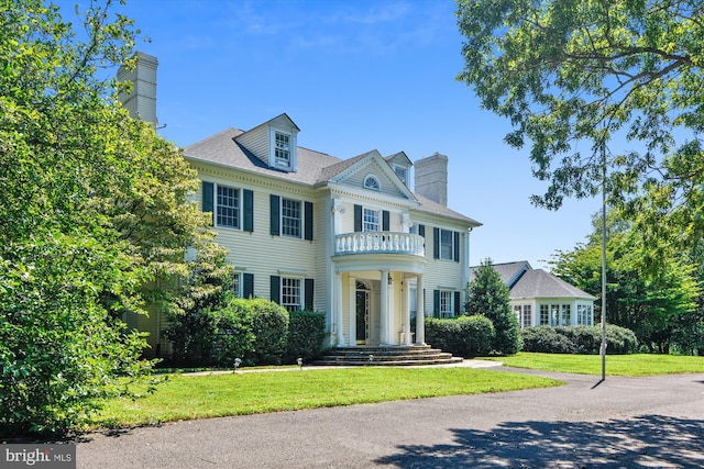 6437 Blantyre, Warrenton, VA 20187 - view of front of property featuring a balcony, a chimney, and a front lawn