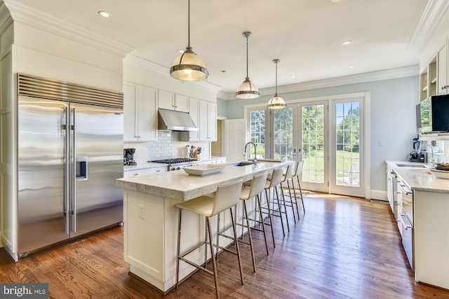 6437 Blantyre, Warrenton, VA 20187 - kitchen with appliances with stainless steel finishes, a sink, under cabinet range hood, decorative backsplash, and white cabinetry