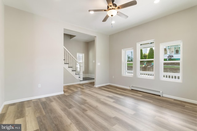407 Lingle St, Osceola Mills, PA 16666 - empty room featuring a baseboard heating unit, stairway, a ceiling fan, wood finished floors, and recessed lighting