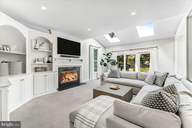 living room with a skylight, a large fireplace, light colored carpet, recessed lighting, and vaulted ceiling