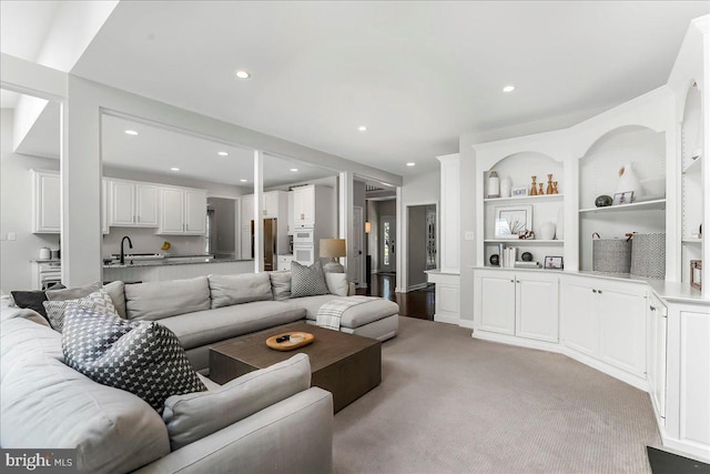 living area featuring light colored carpet, recessed lighting, and built in features