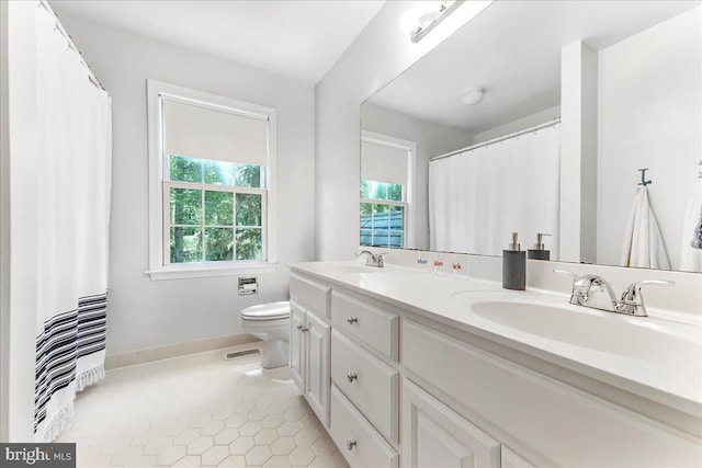 full bathroom with toilet, double vanity, baseboards, and tile patterned flooring