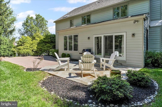 back of house with a patio and a lawn