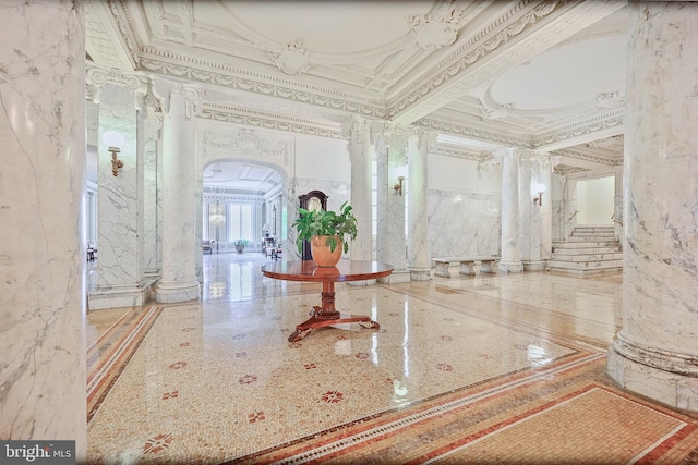 community lobby featuring ornamental molding and a towering ceiling