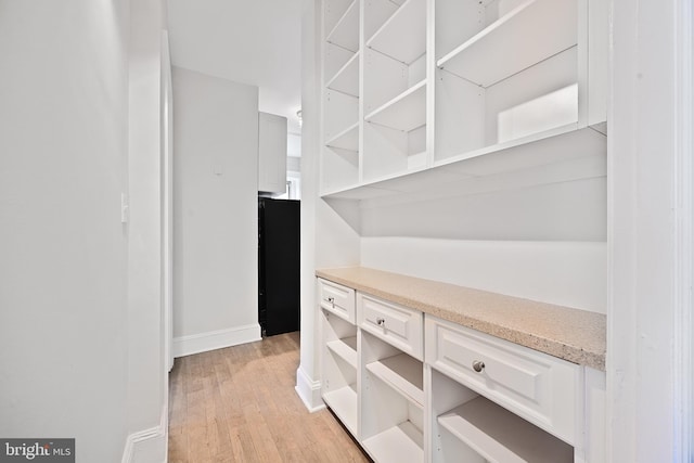 hallway featuring light wood-style floors and baseboards