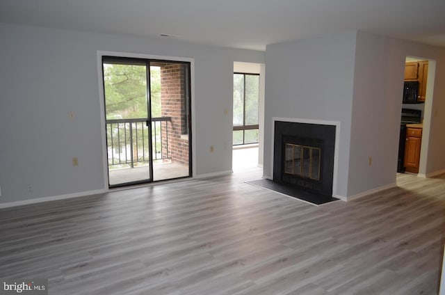 18050 Chalet Dr Unit 14-303, Germantown, MD 20874 - unfurnished living room featuring light wood-type flooring, a fireplace with flush hearth, and baseboards