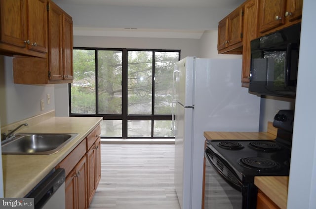 18050 Chalet Dr Unit 14-303, Germantown, MD 20874 - kitchen with black appliances, a sink, light countertops, and brown cabinets