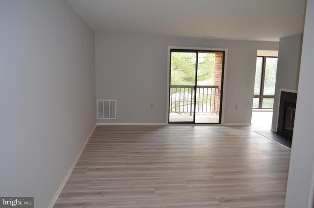 18050 Chalet Dr Unit 14-303, Germantown, MD 20874 - empty room with light wood-style floors, a fireplace with flush hearth, and baseboards