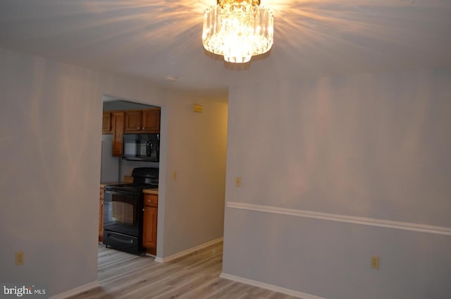18050 Chalet Dr Unit 14-303, Germantown, MD 20874 - kitchen with black appliances, a chandelier, brown cabinets, light wood finished floors, and baseboards