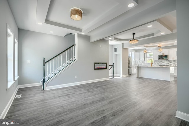 4106 Fleetwood Ave, Baltimore, MD 21206 - unfurnished living room featuring a tray ceiling, recessed lighting, stairs, baseboards, and dark wood finished floors