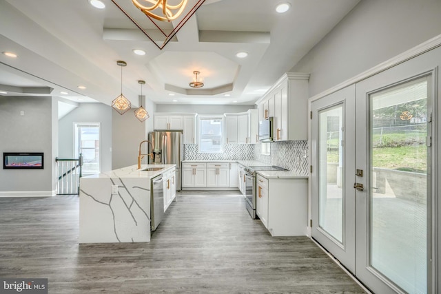4106 Fleetwood Ave, Baltimore, MD 21206 - kitchen featuring appliances with stainless steel finishes, decorative backsplash, light wood-style floors, white cabinetry, and recessed lighting