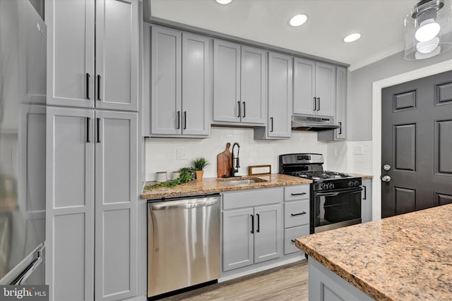 kitchen with stainless steel appliances, a sink, under cabinet range hood, gray cabinetry, and backsplash
