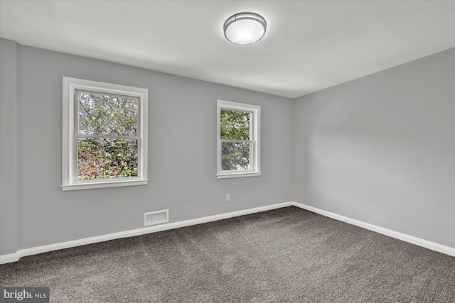 carpeted empty room featuring baseboards