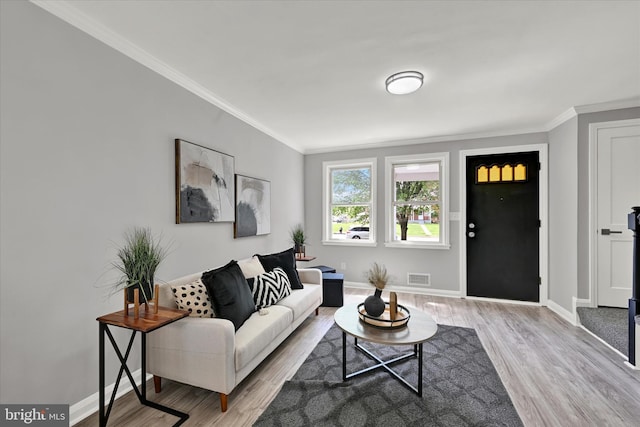 living room featuring ornamental molding, light wood-type flooring, and baseboards
