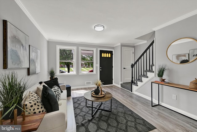 living area with wood finished floors, ornamental molding, stairs, and baseboards