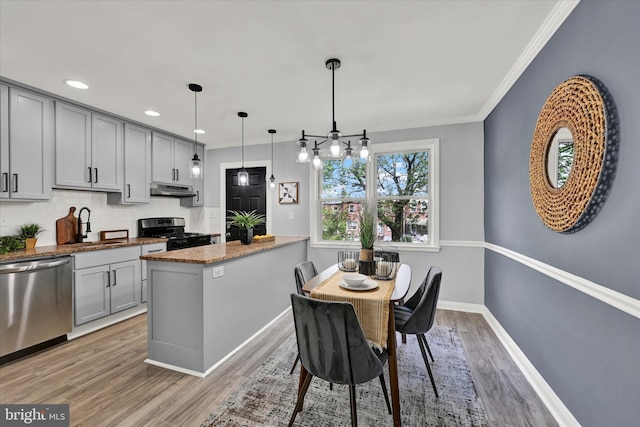 kitchen with dishwasher, range with gas cooktop, a sink, under cabinet range hood, and gray cabinetry