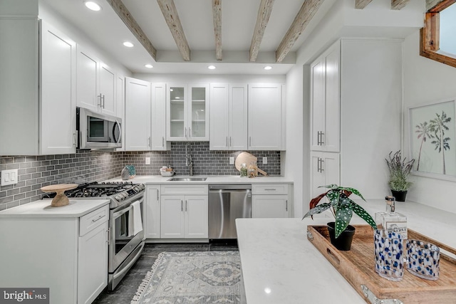 1926 Webster St, Philadelphia, PA 19146 - kitchen with stainless steel appliances, a sink, light countertops, white cabinetry, and decorative backsplash