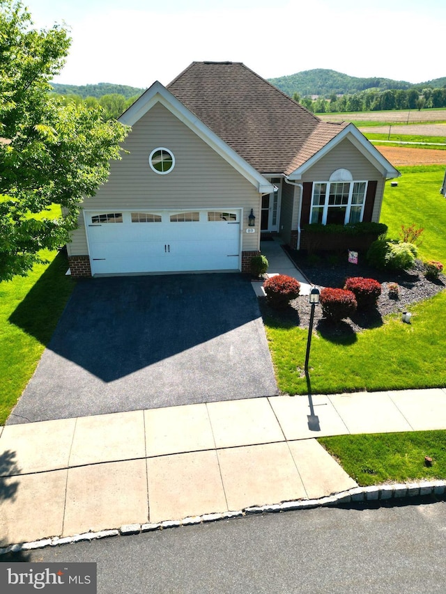 view of front of home with driveway, a garage, a front yard, and a shingled roof