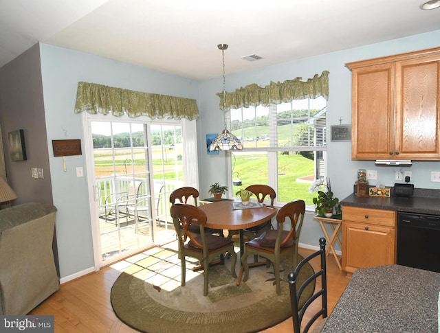 dining area featuring light wood-type flooring, plenty of natural light, and baseboards