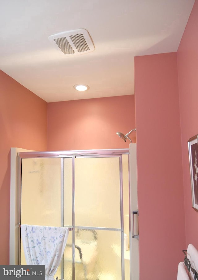bathroom featuring a shower with door and recessed lighting