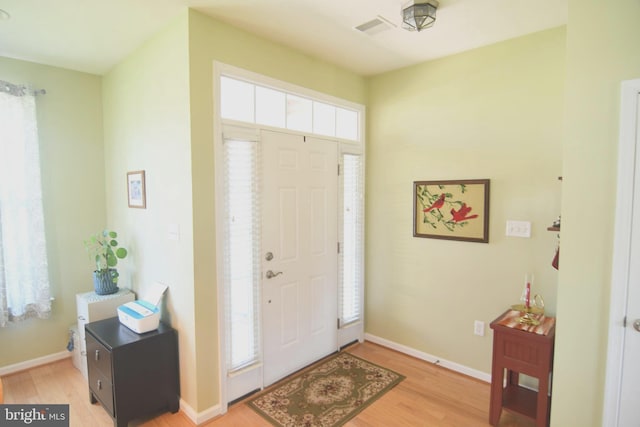 foyer with light wood finished floors and baseboards