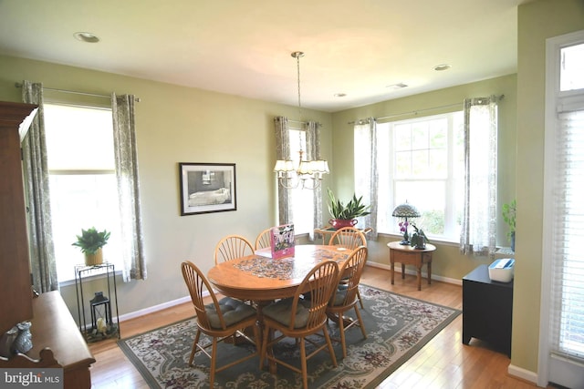 dining room featuring a chandelier, wood finished floors, baseboards, and recessed lighting