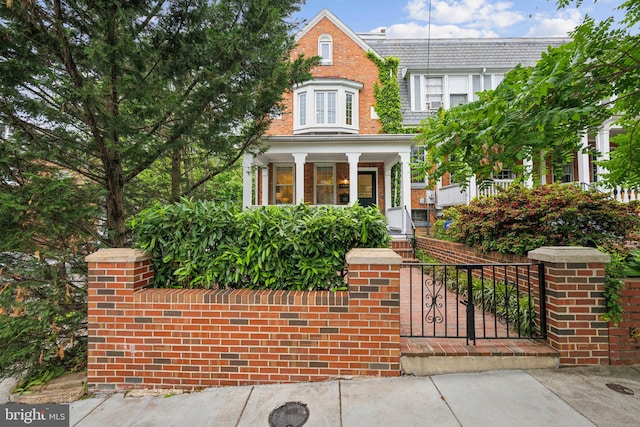 view of front of property featuring a porch and a fenced front yard