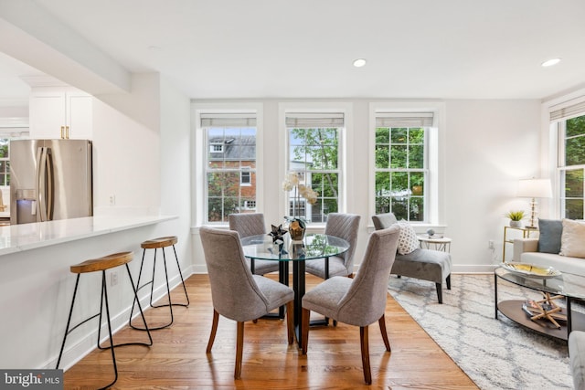 dining space with light wood-type flooring, baseboards, and recessed lighting