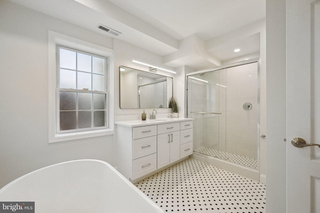 bathroom with a stall shower, vanity, a freestanding bath, and recessed lighting