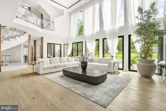 living room featuring hardwood / wood-style flooring, a high ceiling, and stairway