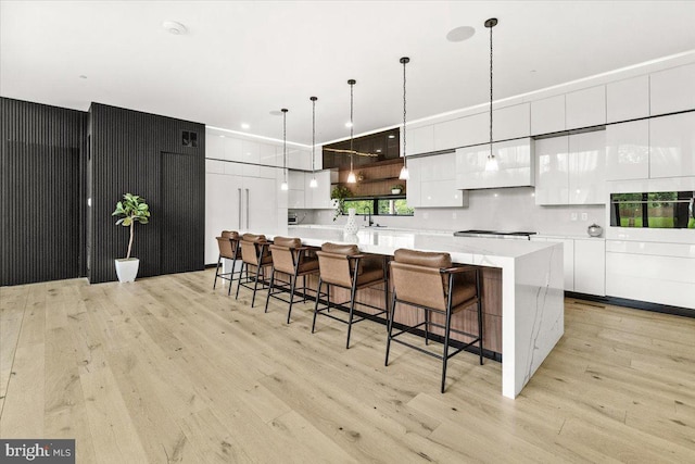 kitchen with light wood-style flooring, white cabinets, modern cabinets, and light countertops