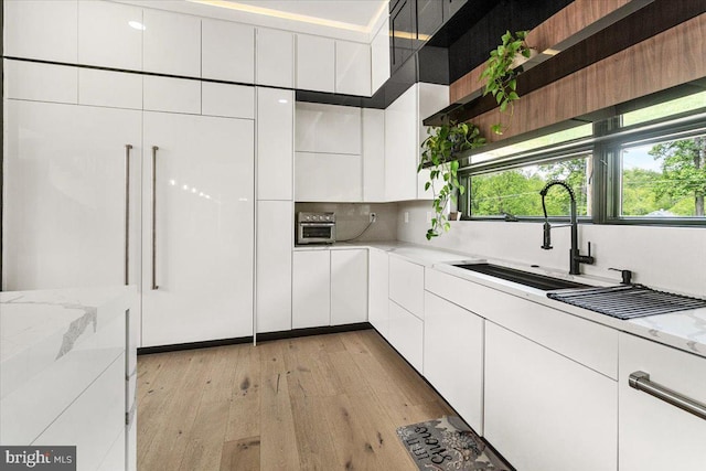 kitchen with white cabinets, light wood-style floors, open shelves, and modern cabinets