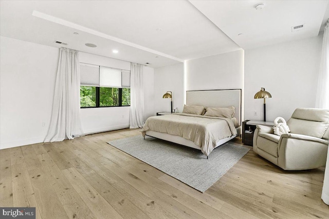 bedroom with light wood finished floors and baseboards