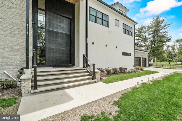 doorway to property with a garage and driveway