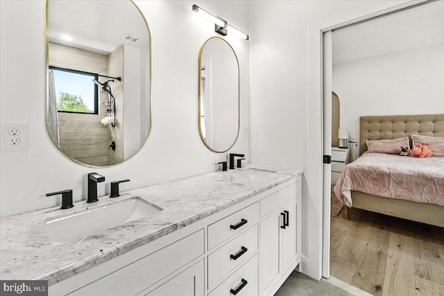 bathroom featuring double vanity and wood finished floors