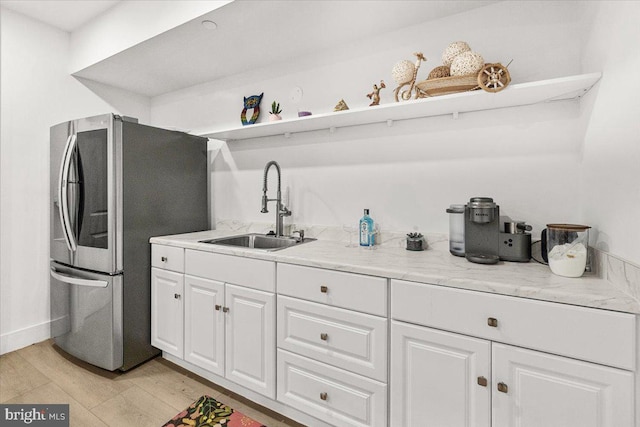 kitchen with a sink, smart refrigerator, white cabinets, open shelves, and light wood-style flooring