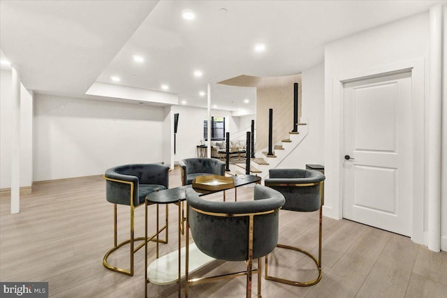 dining space with light wood finished floors, stairs, and recessed lighting
