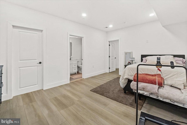 bedroom with light wood finished floors, recessed lighting, baseboards, and ensuite bath