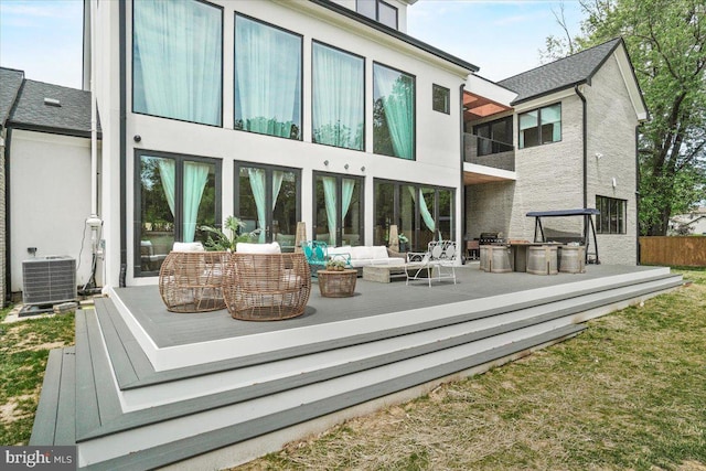 back of property with an outdoor living space, central air condition unit, a wooden deck, and stucco siding
