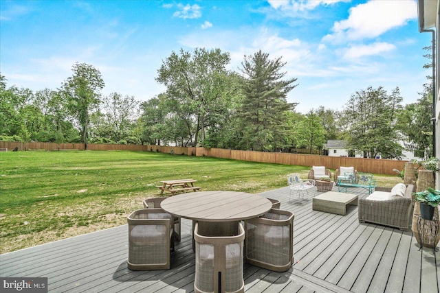 wooden terrace with view of wooded area and an outdoor living space