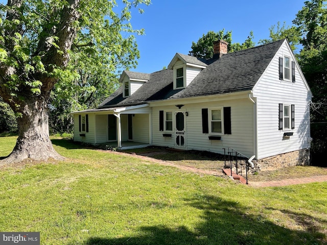 view of front of home with a front yard, a chimney, and a shingled roof