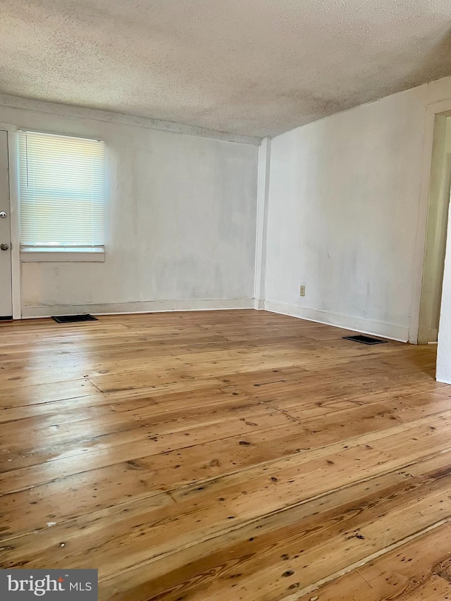 spare room with wood-type flooring and a textured ceiling