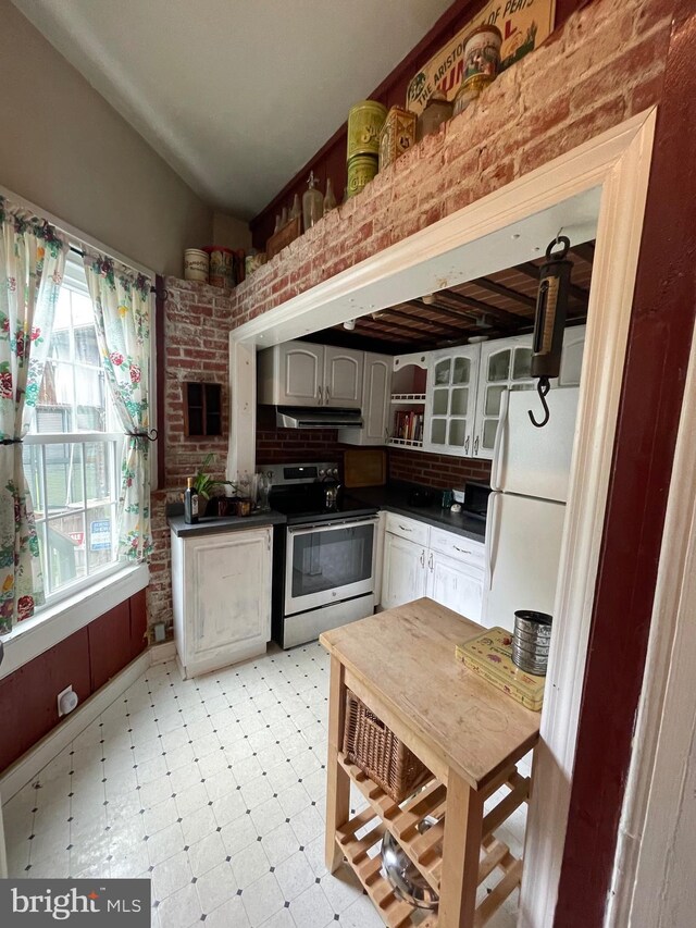 120 Hanover St, Pemberton, NJ 08068 - kitchen with stainless steel electric range oven, freestanding refrigerator, dark countertops, light floors, and brick wall