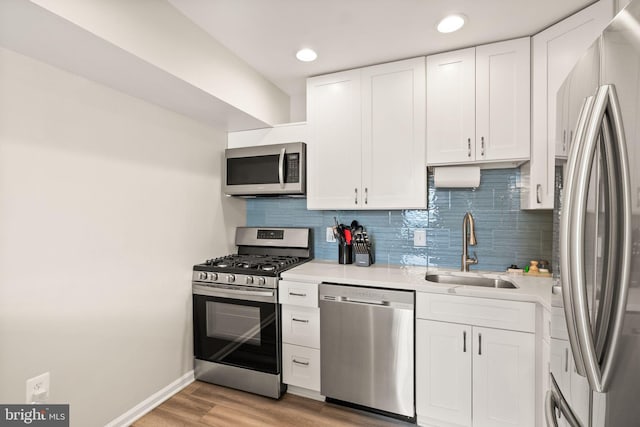 7 Canterbury Sq Unit 401, Alexandria, VA 22304 - kitchen with stainless steel appliances, a sink, white cabinets, backsplash, and recessed lighting