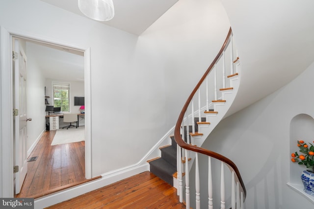 stairway with hardwood / wood-style floors and baseboards