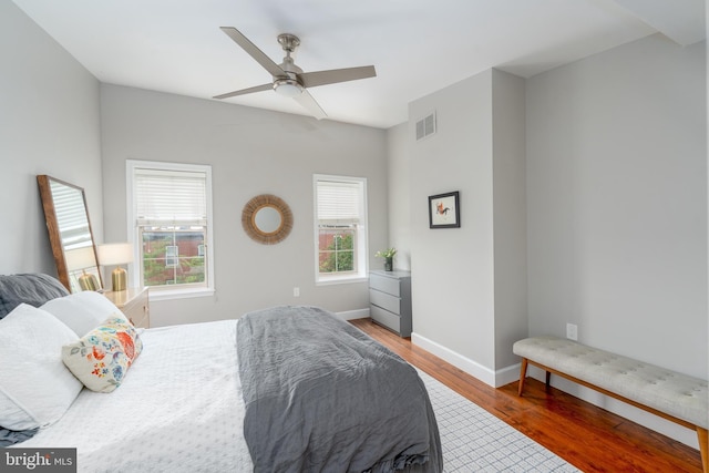 bedroom with wood finished floors, baseboards, and ceiling fan