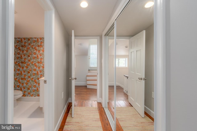 hallway with light wood-style floors and baseboards