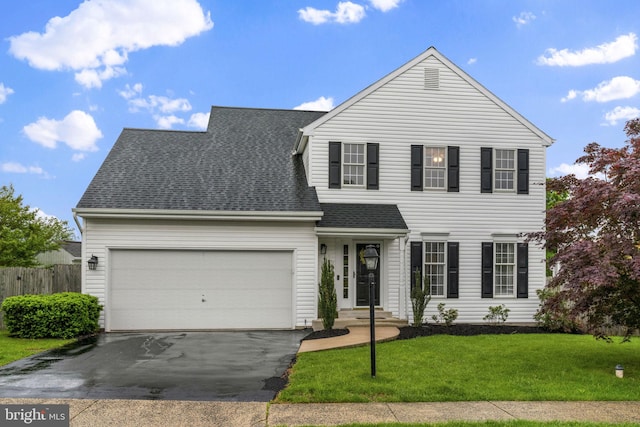 traditional-style house featuring an attached garage, roof with shingles, and driveway